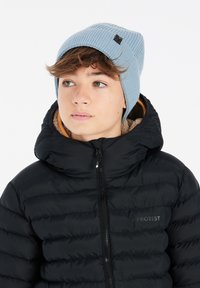 Chaqueta de plumas negra con capucha, con costuras horizontales. Gorro de punto acanalado azul claro con una pequeña etiqueta de logo en el lateral.