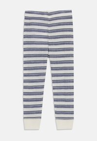 Stripete leggings laget av lett stoff med vekselsvis marineblå og hvite horisontale striper, med tettsittende mansjetter ved anklene.