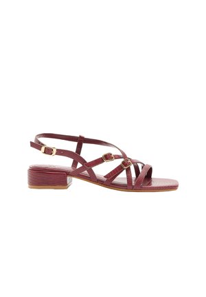 Czerwona sandała na niskim obcasie z cienkimi, teksturowanymi paskami, trzema złotymi klamrami i kwadratowym noskiem, pokazana z boku na białym tle.