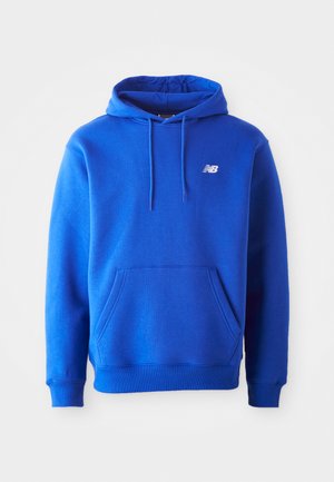 Zila ar kapuci svārku ar kabatu un ribinātiem piedurkņu galiem. Ar baltu logo kreisajā krūtī. Izgatavots no mīksta kokvilnas auduma.