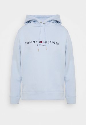 Lichtblauwe hoodie met verstelbare trekkoorden, met de tekst "Tommy Hilfiger", logo in het midden en "Est. 1985" onder het logo.
