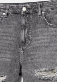Short en denim gris avec bouton frontal, passants de ceinture et déchirures effilochées usées sur les deux jambes près de l'ourlet.