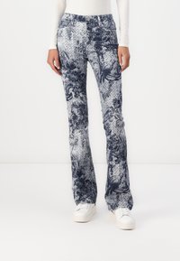 Sbukser med en blå blomstermønster på en lys bakgrunn. Laget av denim, med frontlommer og knappelukking.
