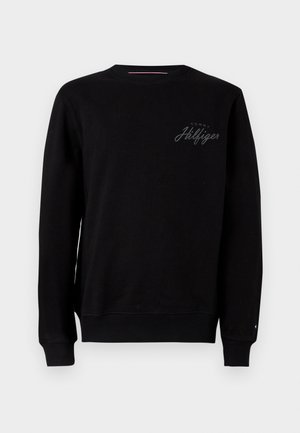 Sort langærmet crewneck sweatshirt med ribbede manchetter og kant, prydet med et lille "Tommy Hilfiger"-logo på brystet og et lille flag på ærmet.