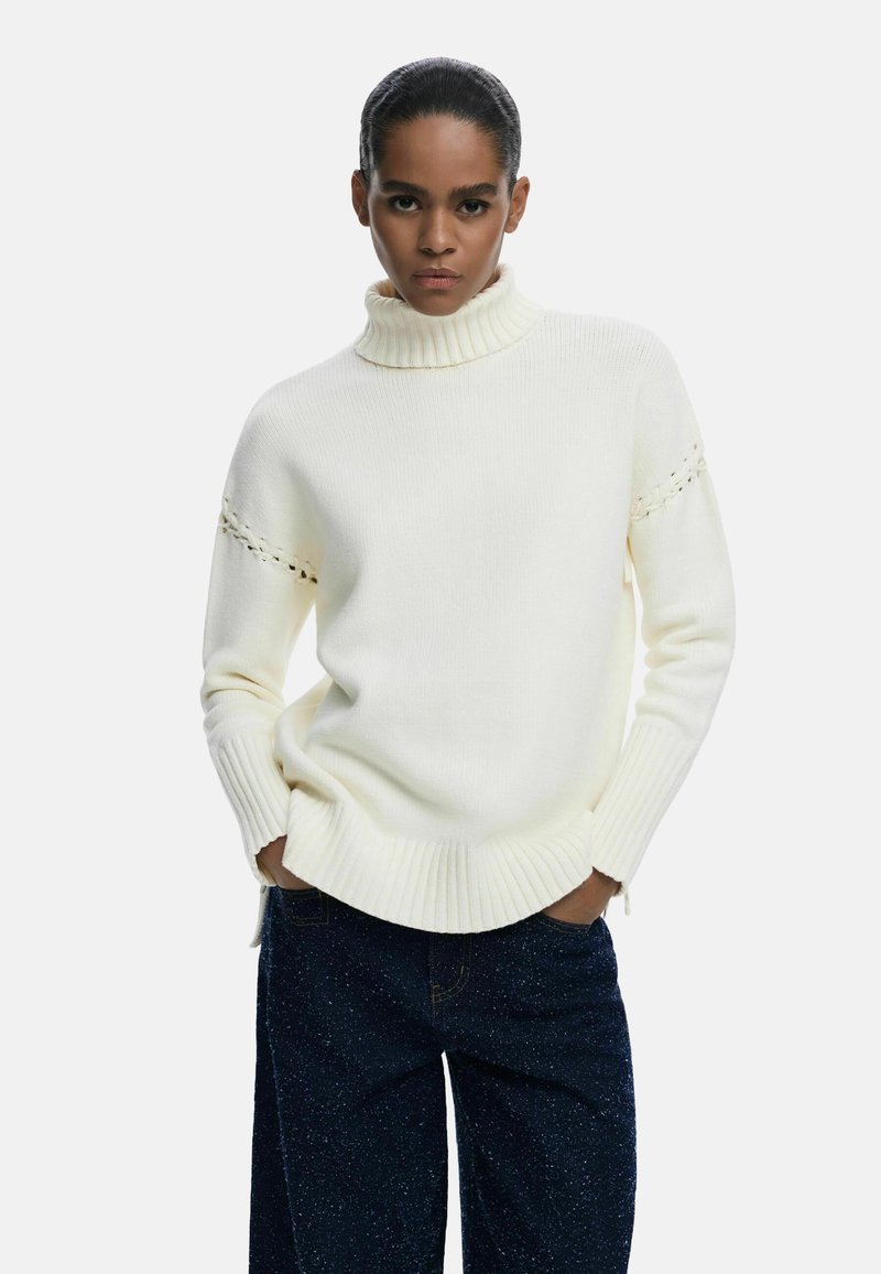 Pulover s turtleneck o kremastoj boji s rebrastim manžetama i rubom, s diskretnim detaljima na ramenima. Meki, teksturirani pleteni materijal.