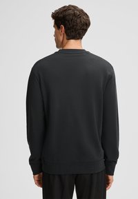 Czarna bluza z długimi rękawami, okrągłym dekoltem, ściągaczami na mankietach i dole; gładka tekstura, minimalistyczny design i klasyczny krój.