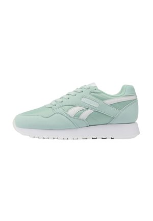 Baskets de sport vert clair avec semelle blanche, bandes blanches du logo et lacets, vues de côté sur fond blanc.