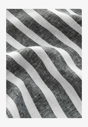 Svart och vit randig tyg med en texturerad väv, med växlande breda och smala ränder i en slät, mjuk finish.