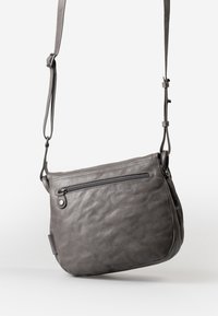 Borsa a tracolla grigia in pelle con superficie strutturata, tracolla regolabile e tasca con zip frontale dotata di un tirazip rotondo.