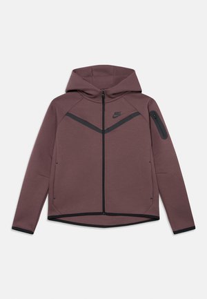 Donker mauve Nike capuchonjas met ritssluiting, zwarte chevron-detail, een ritssluiting zak op de linker mouw en zwarte afwerking aan de manchetten en zoom.