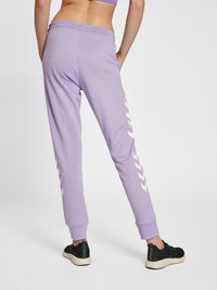 Lilla sweatpants lavet af blødt stof har en tapered pasform, elastisk talje og hvide chevron-detaljer langs siderne.
