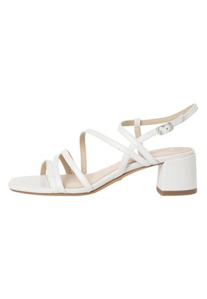 Weiße Sandale mit Absatz, mehreren übereinanderliegenden Riemen, verstellbarem Knöchelriemen und Blockabsatz. Glatte Textur mit minimalistischem Design.