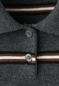 Polo in maglia grigia con colletto scuro, due bottoni e strisce orizzontali marroni e bianche sul petto.