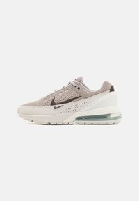 Ljust grå mesh atletisk sko med vit mellansula och transparent luftdämpning. Har mörkgrå accenter och en texturerad ovandel.