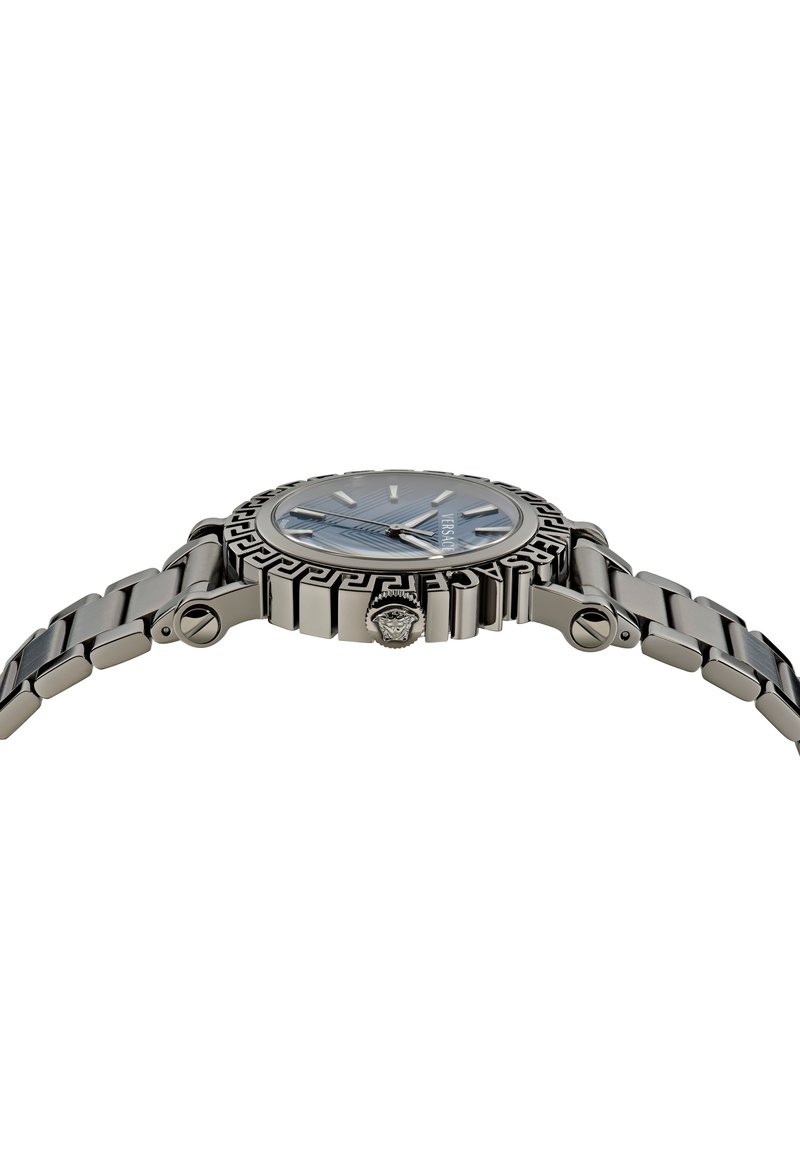 Montre-bracelet en métal argenté avec un cadran bleu, détails en motif sur la lunette et un bracelet texturé. Comprend une couronne avec un accent de logo.