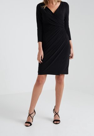 Schwarzes Wickelkleid mit V-Ausschnitt, dreiviertellangen Ärmeln und figurbetonter Silhouette. Hergestellt aus weichem, strukturiertem Stoff, gestaltet mit drapierten Details.