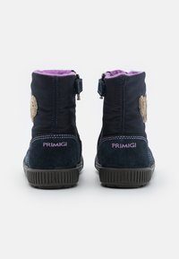 Mörkblå ankelstövlar med mjuk lila foder, dekorativa bruna lappar och sidodragkedjor; märkta med "PRIMIGI"-logotypen. Gummisula.