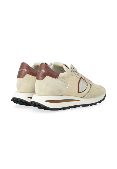 Sneaker in suede beige e marrone con suole bianche, suole nere, design con lacci e logo del marchio sul tallone.