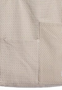 Bézs színű szövet függőleges csíkos mintával. Jellemzője egy téglalap alakú zseb, sima textúra és varrott szegélyek.