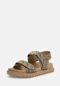 Beige stoffen sandalen met patroonbandjes, voorzien van een chunky beige zool en metalen hardware accenten.