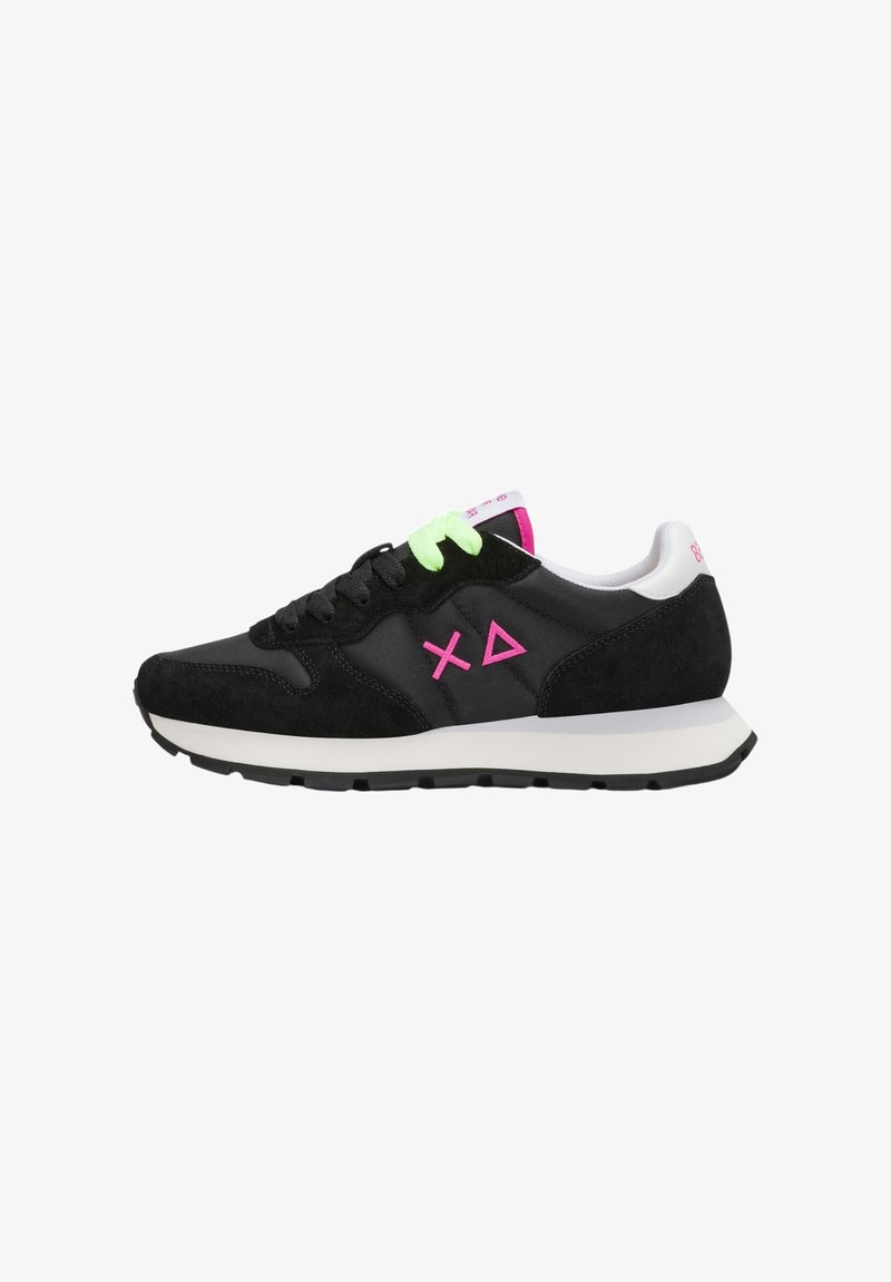 Zapatilla deportiva negra de corte bajo con suela blanca, cordones en negro y verde neón, logo geométrico rosa y collarín del talón blanco.