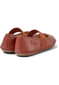 Rote Leder-Ballettschuhe mit elastischen Riemen, runder Form und glatter Textur. Mit einem dezenten Logo an der Ferse.