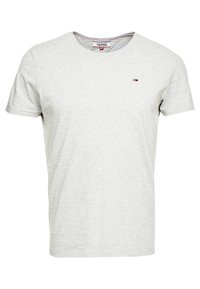 Szara koszulka t-shirt z krótkim rękawem, wykonana z bawełny, z okrągłym dekoltem i małym logo w kolorach czerwonym, białym i niebieskim po lewej stronie klatki piersiowej.