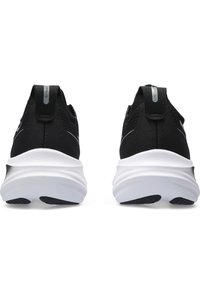 Baskets de sport noires avec un dessus en tissu texturé, une intermédiaire blanche et une semelle en caoutchouc noir. Présente une languette au niveau du talon.