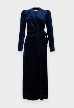 Navyblauwe fluwelen wikkeljurk met lange puffmouwen, V-hals en een strik in de taille, die tot aan de enkels reikt.