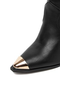 Czarne skórzane botki za kostkę z spiczastym czubkiem i metalicznym złotym akcentem. Gładka tekstura, minimalistyczny design i płaska gumowa podeszwa.