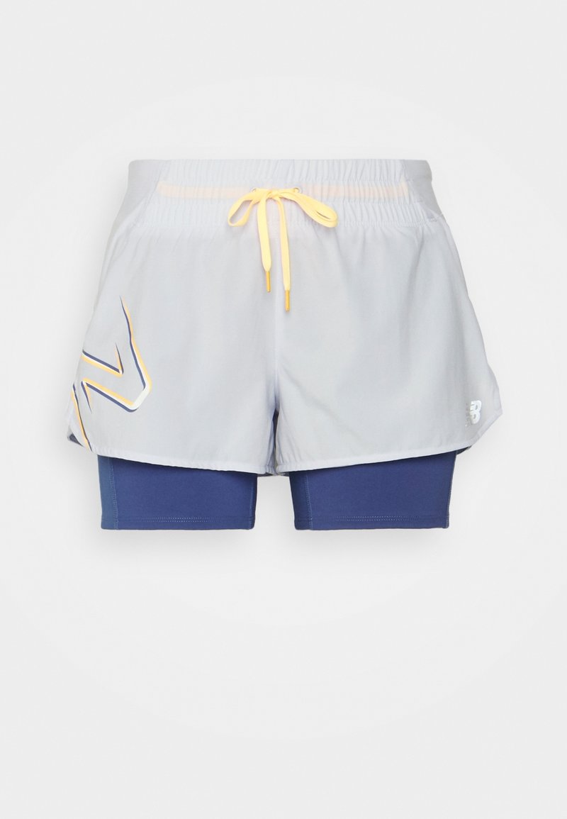 Ljust grå träningsshorts med gul dragsko och blåa innerbyxor med åtsittande passform, med en stiliserad logotyp på det vänstra ytterlagret.