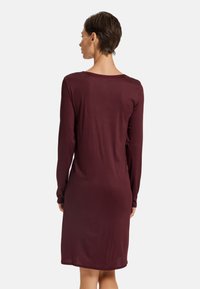 Burgundy långärmad klänning, mjukt material, rund halsringning, knä-lång, åtsittande silhuett, slät textur, minimal detaljer, inga synliga knäppningar.