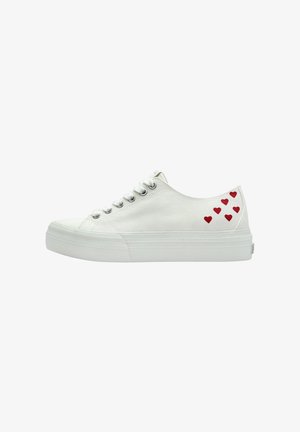 White canvas sneakers with a round toe, flat sole, and silver eyelets. Red heart patterns on the outer side add detail.