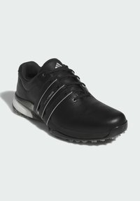 Černé kožené golfové boty s elegantním designem, texturovaným svrškem, kontrastními bílými akcenty a špičatou podrážkou pro lepší trakci.