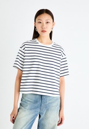 White t-shirt with navy horizontal stripes, short sleeves, and a crew neckline. Paired with light blue denim jeans. Plain background.