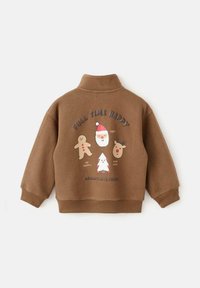 Felpa marrone con colletto alto che presenta grafiche colorate a tema natalizio: un omino di pan di zenzero, Babbo Natale, una renna e un albero.