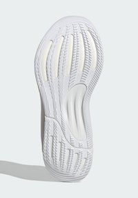 Semelle de chaussure de sport blanche avec une adhérence en caoutchouc texturé, présentant des rainures et des découpes pour la flexibilité, des bords lisses et une forme ergonomique.