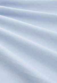 Šviesiai mėlynas audinys su lygiu tekstūra, rodantis švelnias raukšles ir subtilią blizgesį, pabrėžiantis lengvą ir kvėpuojančią išvaizdą.