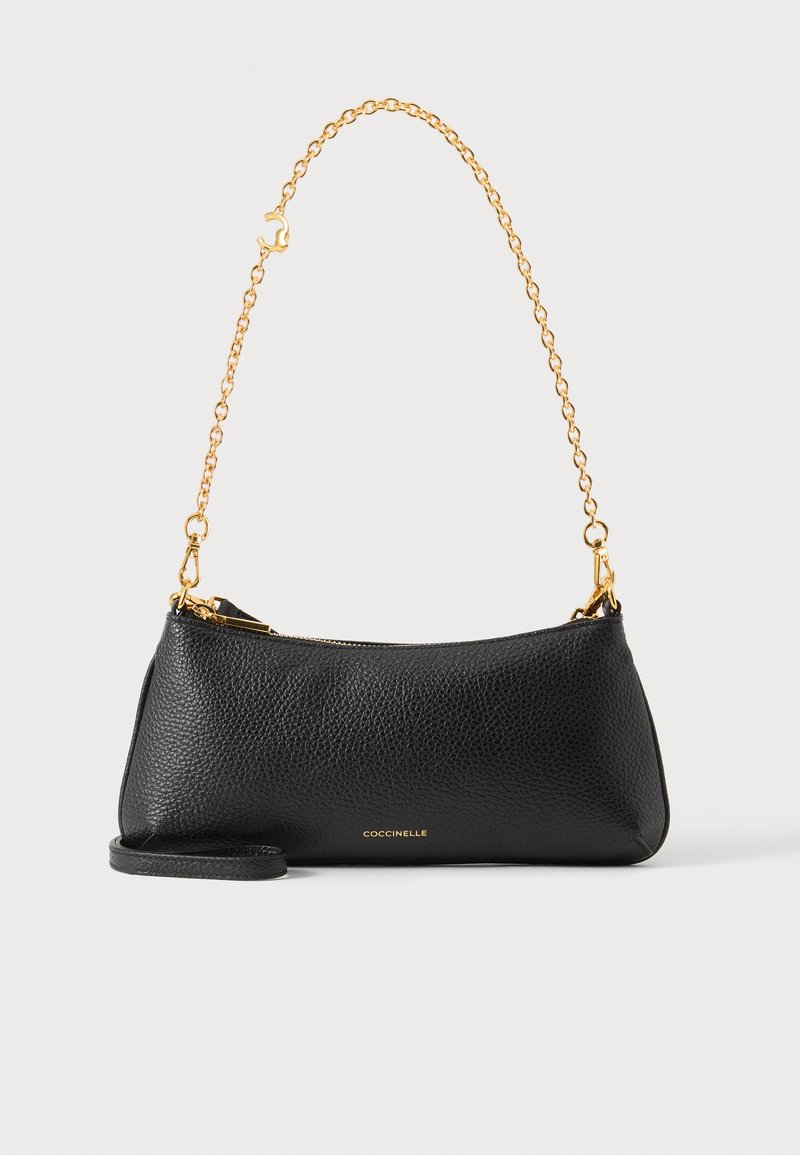 Sac à épaule en cuir texturé noir avec bandoulière chaîne dorée et fermeture éclair, petite forme rectangulaire, logo "Coccinelle" en lettres dorées.