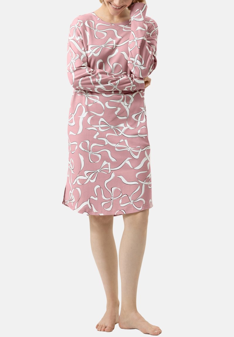 Långärmad klänning i rosa bomull med ett vitt ränder mönster. Har rund halsringning och sidofickor för ökad komfort.