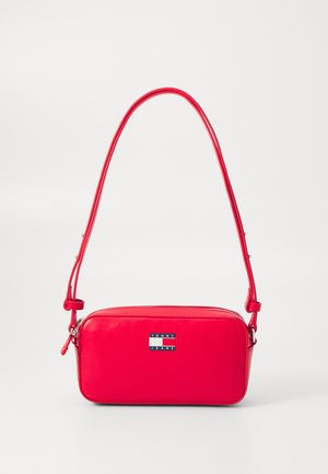 Crvena kožna torba preko tijela pravokutnog oblika, s pločicom s logotipom, zatvaranjem na patentni zatvarač i podesivim remenom za rame.