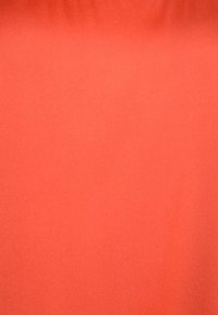 Tessuto in corallo solido con una texture liscia e una leggera lucentezza, che mostra un colore uniforme e senza motivi o embellishments visibili.