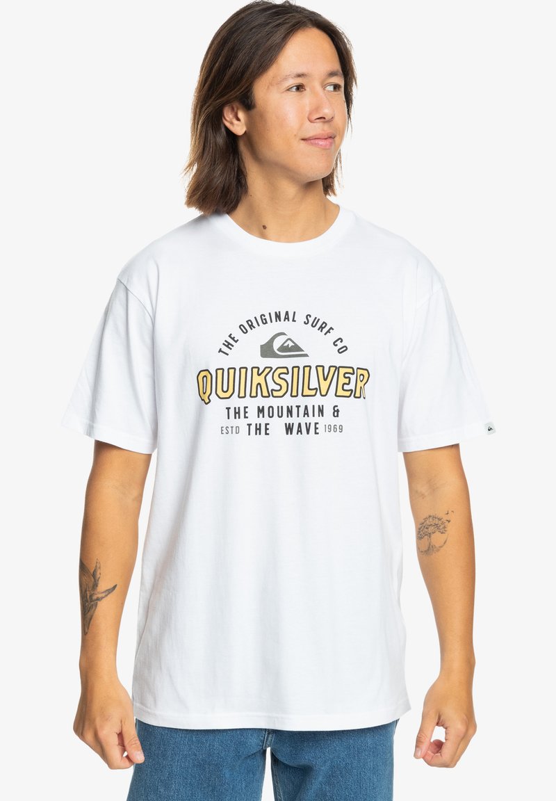 White cotton t-shirt with short sleeves, featuring a black and yellow graphic text reading "Quiksilver." Straight hem and relaxed fit.