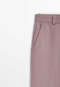 Op maat gemaakte broeken in een gedempte lavendelkleur. Gemaakt van een gestructureerde stof met een flatte tailleband en voorzakken.