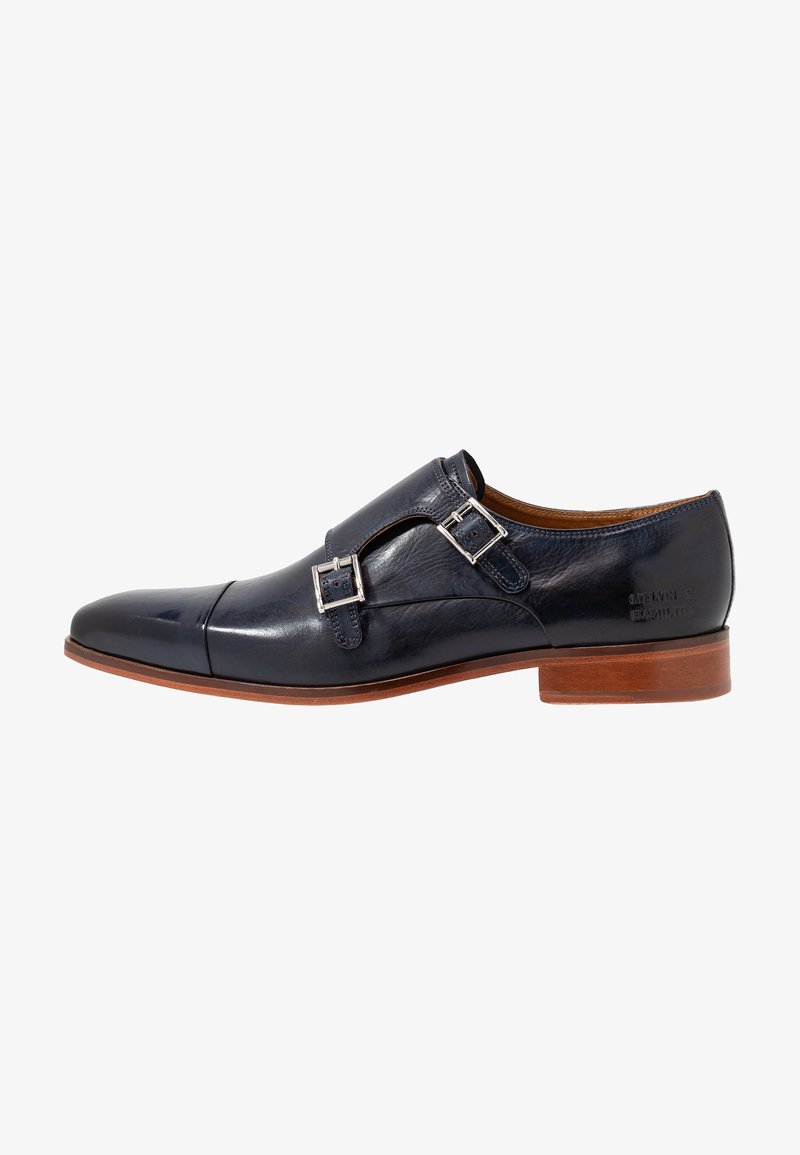 Chaussure habillée en cuir noir à double boucle de type monk avec boucles argentées, semelle marron, talon bas et bout arrondi.