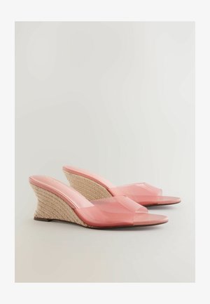 Różowe przezroczyste sandały na koturnie z plecionym obcasem z juty, z odkrytą palcą i szerokim paskiem na wierzchu stopy.