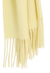 Bufanda de lana amarilla con textura suave, con bordes desflecados. La tela parece lisa y ligera, adecuada para usar en capas.