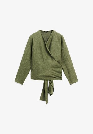 Groene linnen wikkeltop met lange mouwen, V-hals en een strik in de taille. De textuur is iets ruw, met een natuurlijke afwerking.