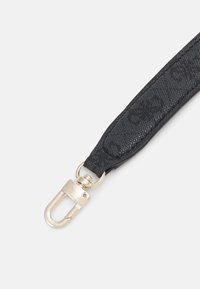 Czarny materiałowy pasek z fakturowanym wzorem i zapięciem z metalu w złotym odcieniu do mocowania. Zawiera metalowy pierścień w kształcie koła.