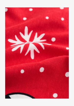 Raudona, minkšta tekstūra turinti medžiaga su baltais taškeliais ir gėlių motyvu centre. Dizainas yra ryškus ir žaismingas.